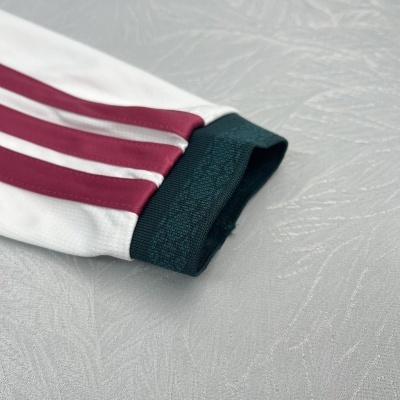 Manga de roupa branca com riscas vermelhas e punho verde escuro