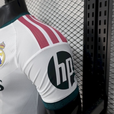 Manga de camisola desportiva branca com riscas vermelhas, logo hp preto e emblema Real Madrid