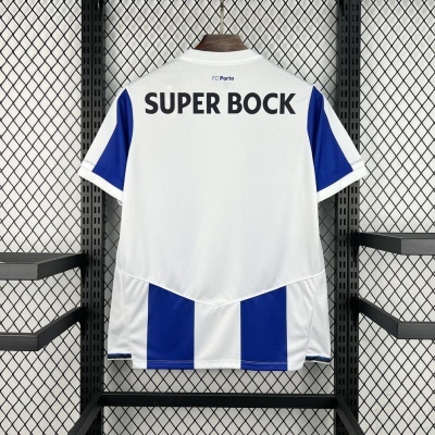 Camisola FC Porto branca e azul com texto SUPER BOCK pendurada numa estrutura metálica