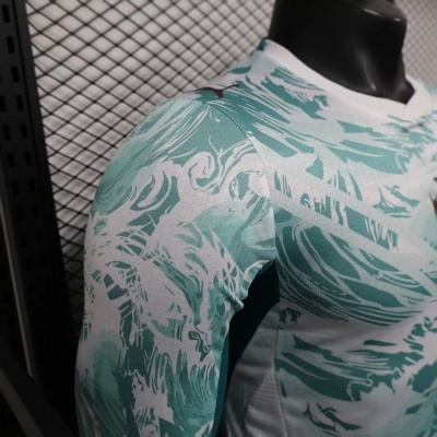 Camisola desportiva verde e branca com padrão abstrato e logo Puma em manequim