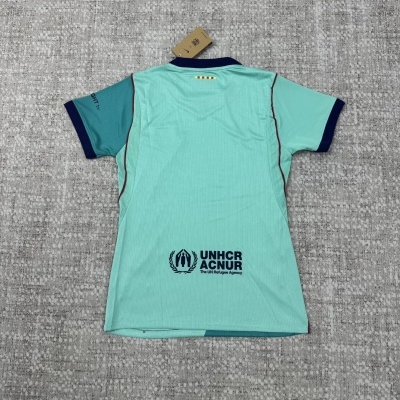 Camisola azul turquesa com detalhes em azul escuro e vermelho, texto UNHCR ACNUR na parte traseira