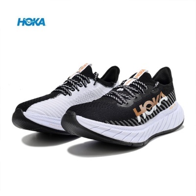 Sapatilhas de corrida HOKA preta e branca com sola grossa e logotipo na lateral