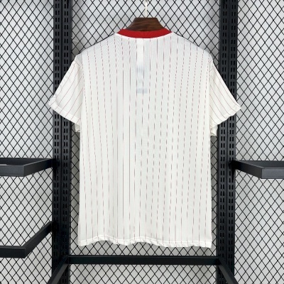T-shirt branca com riscas vermelhas verticais e gola vermelha pendurada em cabide