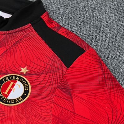 Camisola vermelha de futebol com emblema Feyenoord Rotterdam e padrão geométrico negro