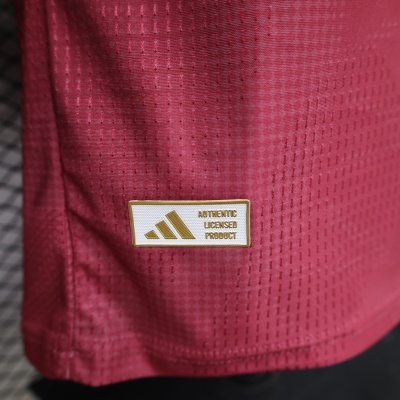 Etiqueta dourada e branca em tecido desportivo vermelho com textura