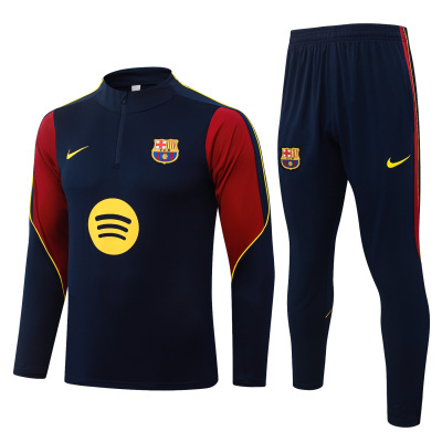 Conjunto de treino azul escuro com detalhes vermelhos e amarelos, emblema FCB e logo Nike amarelo