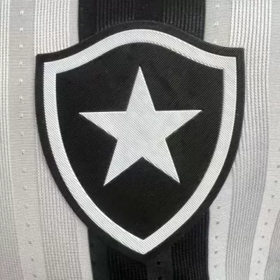Escudo bordado preto e branco com estrela, sobre tecido com riscas verticais