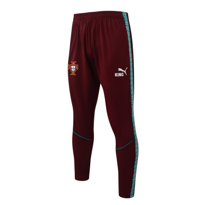 Calças desportivas bordeaux com risca lateral verde e detalhes brancos.