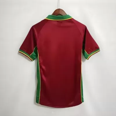 Camisola desportiva vermelha com detalhes verdes e amarelos pendurada numa cabide de madeira