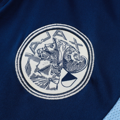 Emblema bordado JAJAX em tecido azul escuro com azul claro perfurado