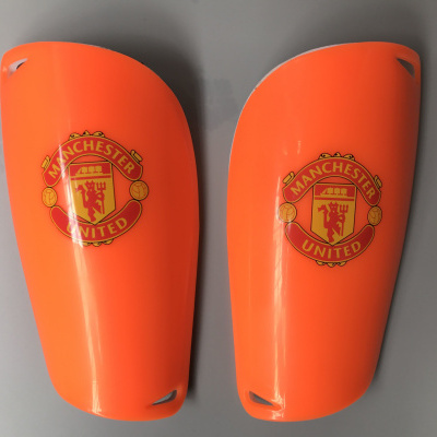 Par de caneleiras desportivas laranja com emblema Manchester United