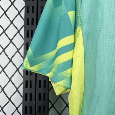 Manga de camisola desportiva verde e amarelo pendurada numa estrutura metálica preta