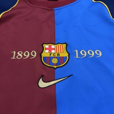 Camisola de futebol azul e grená com emblema FCB e números 1899 e 1999 bordados