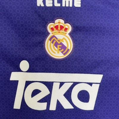 Tecido azul desportivo com emblema e texto bordado e impresso