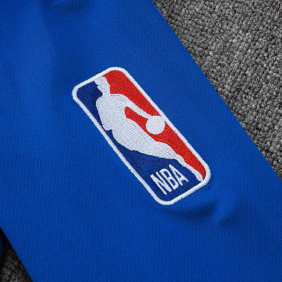 Peça de roupa azul com logo NBA bordado em fundo cinza