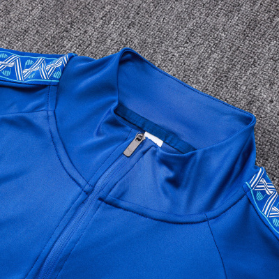 Parte superior de roupa desportiva azul com fecho e padrão lateral