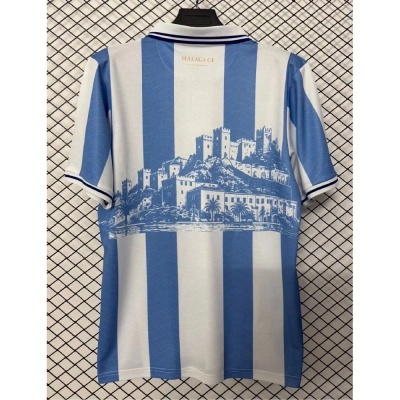 T-shirt azul e branca riscada com estampa de castelo e texto Málaga CF na gola