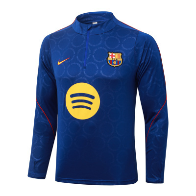 Camisola desportiva azul do FC Barcelona com logo Spotify e detalhes vermelhos.