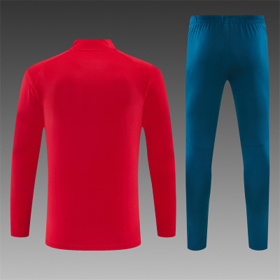 Conjunto desportivo com camisola vermelha e calças azuis de costas