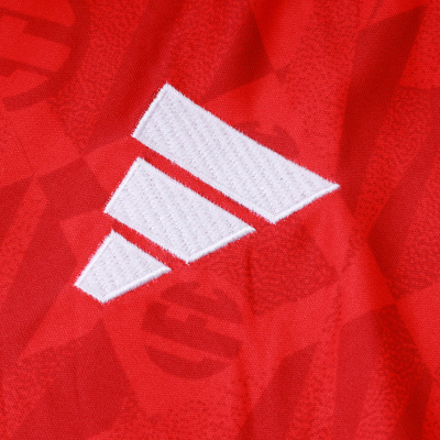 Logótipo Adidas branco bordado em tecido vermelho com padrão geométrico