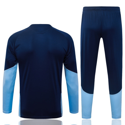 Conjunto desportivo azul escuro e azul claro com camisola de manga comprida e calças.