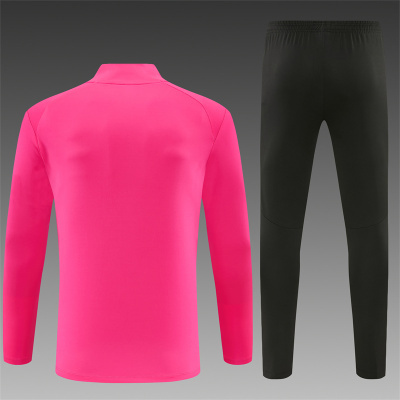 Conjunto desportivo rosa e preto, camisola de manga comprida e calças justas com cintura elástica.