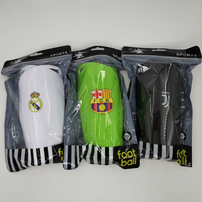 Três canecas de plástico com emblemas de clubes de futebol em embalagens transparentes.