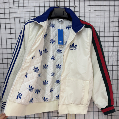 Casaco desportivo creme com padrão GUCCI e adidas nas mangas e interior.