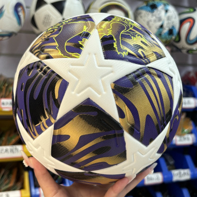 Bola de futebol branca com padrão roxo e dourado e estrelas em relevo
