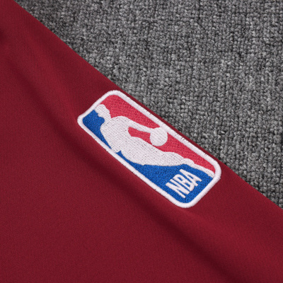 Tecido vermelho com logo bordado da NBA sobre carpete cinzento