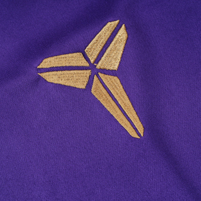 Logotipo bordado dourado em tecido roxo