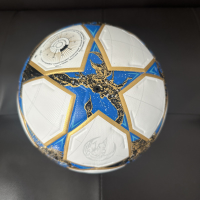 Bola de futebol branca com estrelas azuis e douradas e figuras douradas