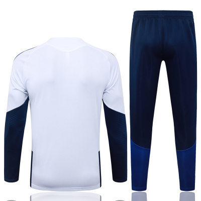 Conjunto de roupa desportiva com camisola branca e azul escura e calças azul escuras