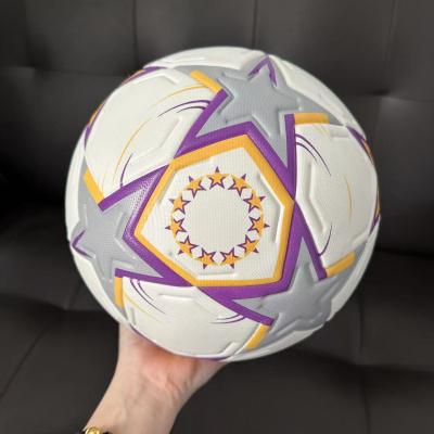 Bola de futebol branca com estrelas cinzentas e detalhes roxos e amarelos