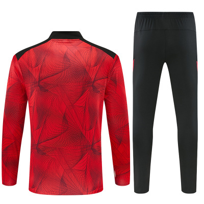 Conjunto de roupa desportiva vermelho e preto com padrão abstrato.