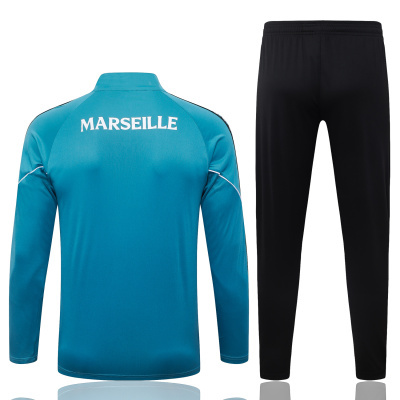Roupa desportiva azul com calças pretas e texto MARSEILLE nas costas