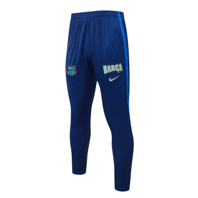 Calças de treino azul-escuro com logótipos Barça e FCB