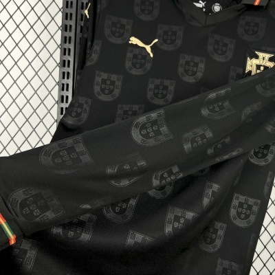 Camisola preta com escudo de Portugal repetido, logótipo dourado Puma e punhos com riscas da bandeira portuguesa
