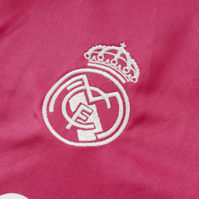 Tecido rosa com logótipo bordado do Real Madrid e detalhe branco perfurado.