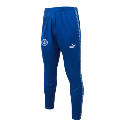 Calças de treino azuis com logo Puma e emblema Manchester City.