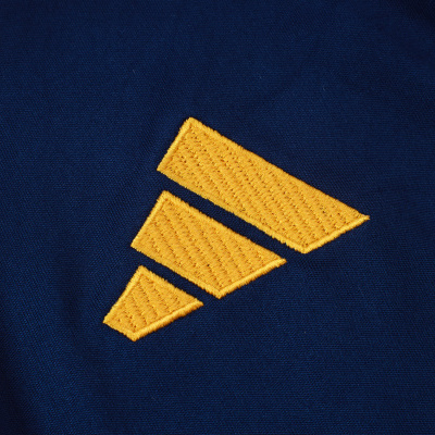 Tecido azul com bordado amarelo e faixa lateral perfurada