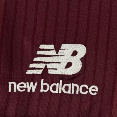 Logótipo bordado branco da New Balance em tecido malha bordô