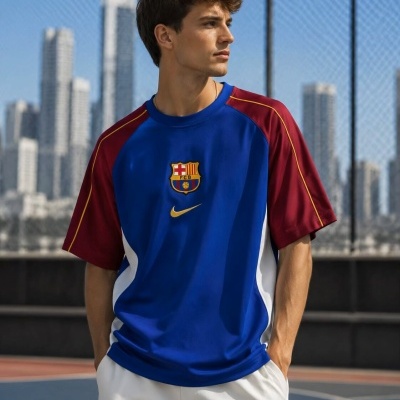 Homem com camisola azul do FCB e símbolo Nike amarelo num campo de basquetebol ao ar livre