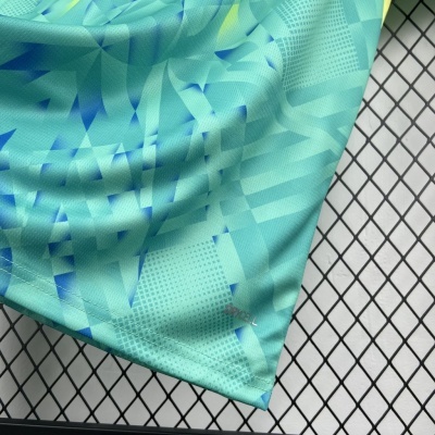 Tecido azul e verde água com padrão geométrico e texto DRYCELL junto a costura em grade metálica.