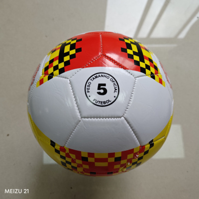 Bola de futebol branca com padrão vermelho, amarelo e preto, costuras visíveis.