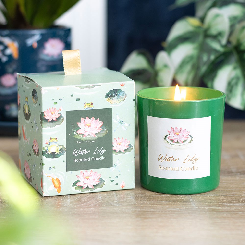 Vela aromática verde com embalagem de cartão decorada e rótulo com flor-de-lótus