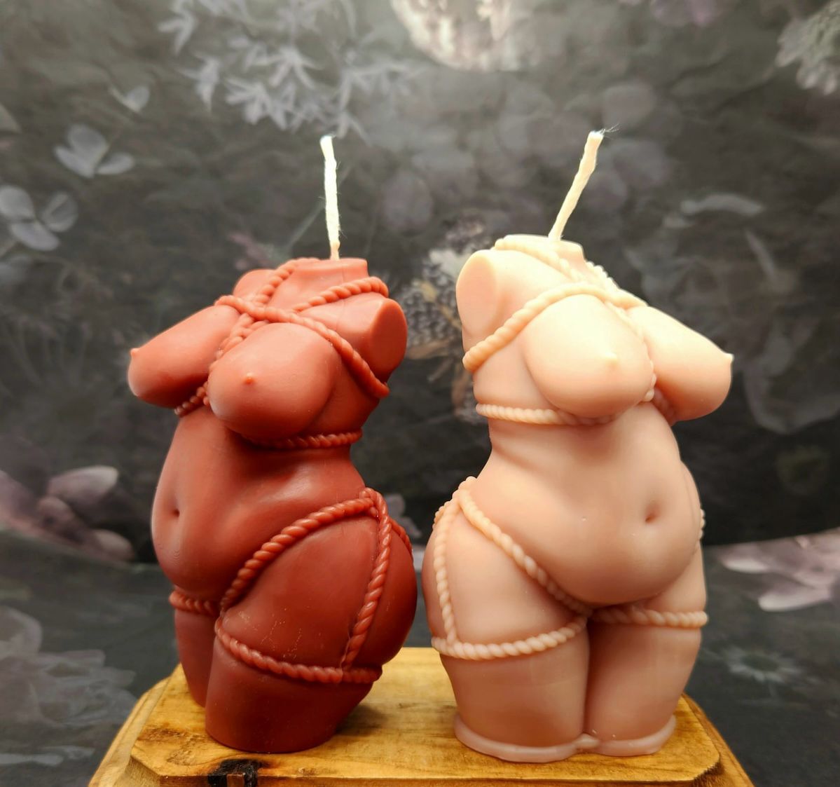 Vela Aromática Corpo Feminino Velas em forma de torso feminino em duas cores, castanho avermelhado e bege, com decoração de corda, sobre base de madeira