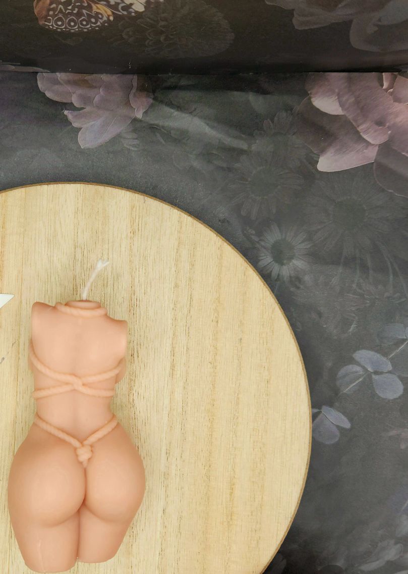Vela Aromática Corpo Feminino Vela em forma de tronco feminino com cordas, sobre base redonda de madeira