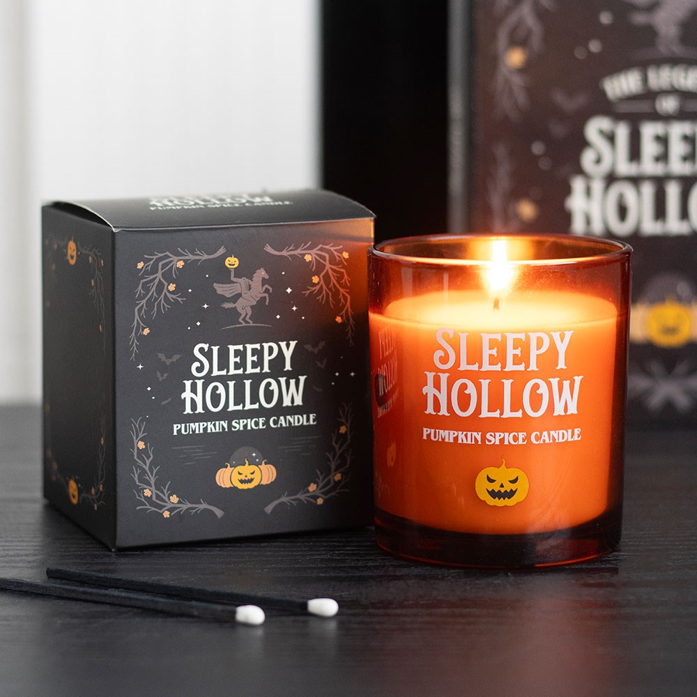 Vela laranja acesa com embalagem preta do produto Sleepy Hollow Pumpkin Spice Candle