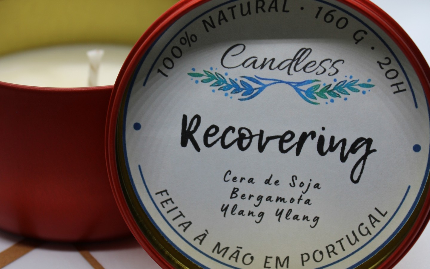 Vela em lata vermelha com etiqueta branca e texto sobre a fragrância e características